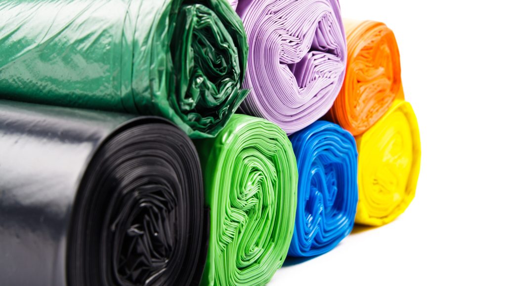 Colored garbage bags on white background