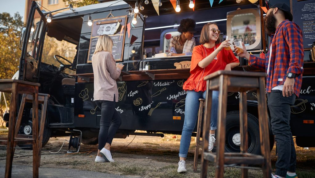 people enjoying in front of modified truck for mobile fast food service