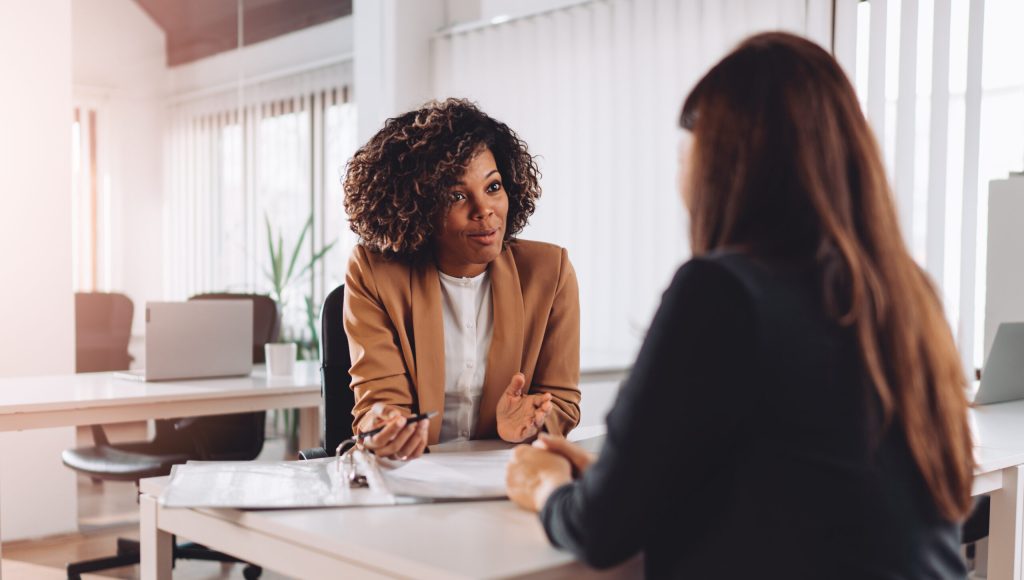 Young woman doing a job interview in the office and talking with client