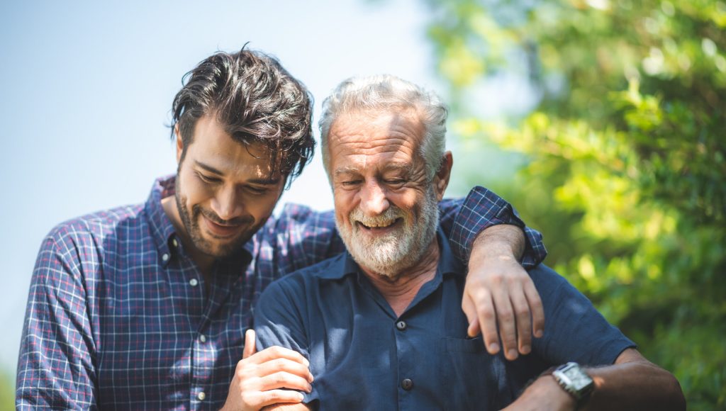 caucasian senior father and adult son are hugging together at home, generation family are happy with people love, male mature, old person man, elderly grandfather smiling living at the house