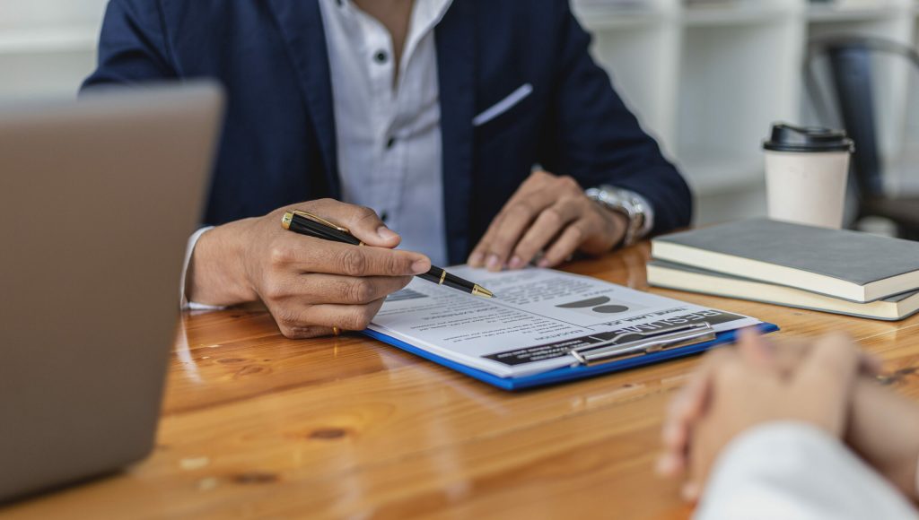 The HR manager is interviewing job applicants. He is reviewing the eligibility of applicants from her resume. Job interview ideas. The company is accepting employees for work and interview.