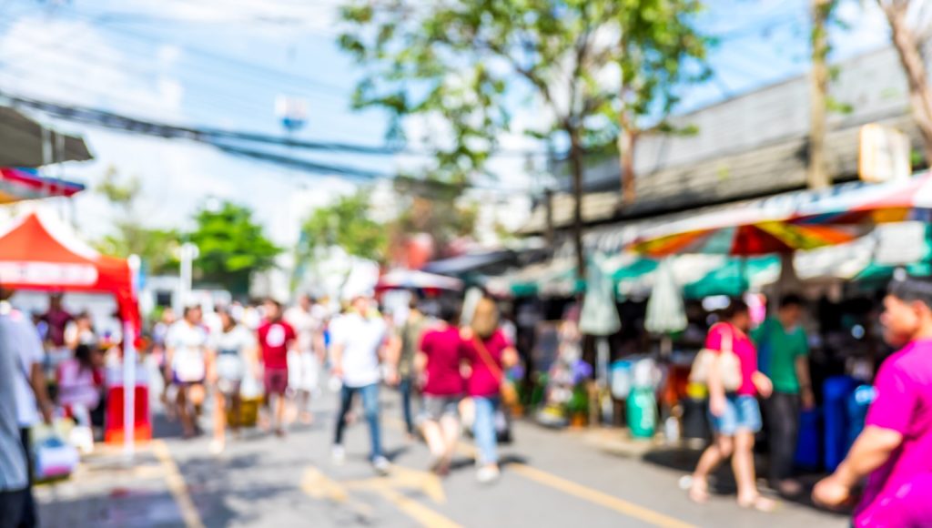 Blurred background : people shopping at market fair in sunny day, blur background with bokeh.